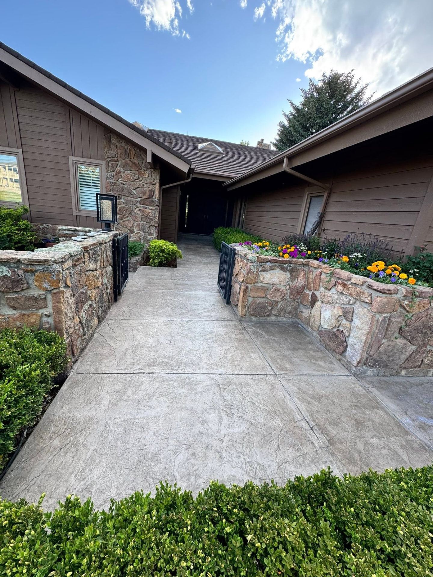 Wide stamped concrete courtyard walkway with flower beds